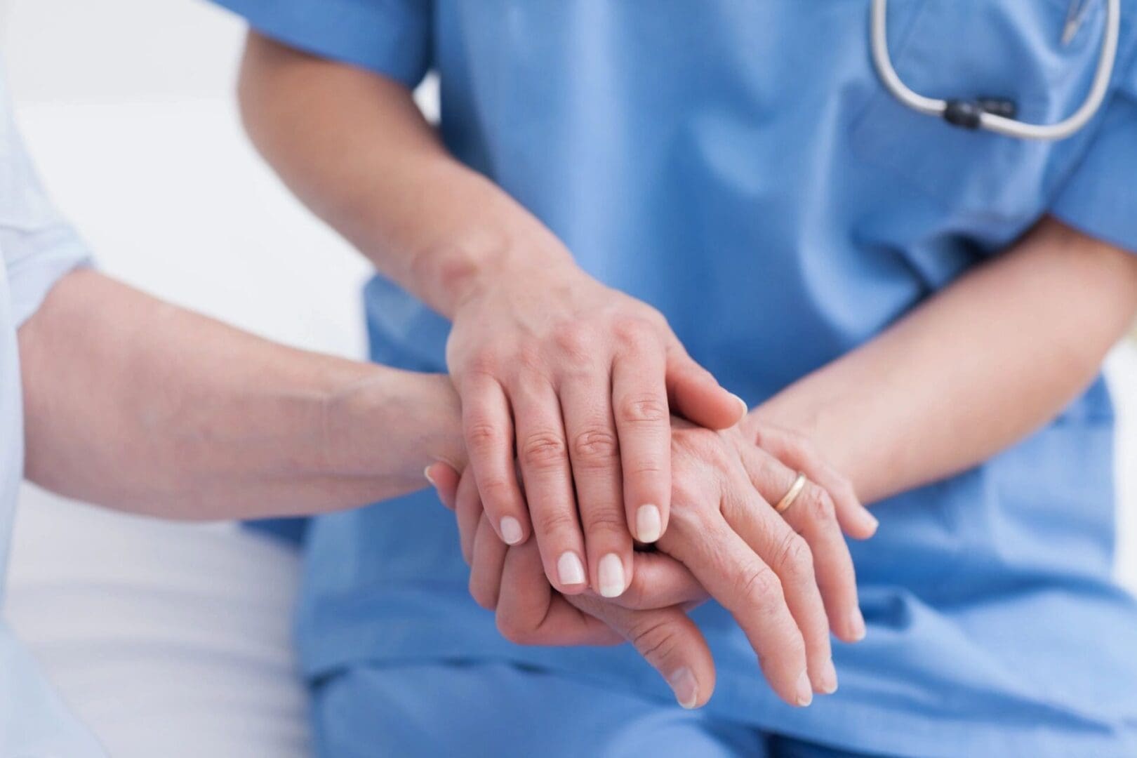 A nurse is holding a patient's hand.