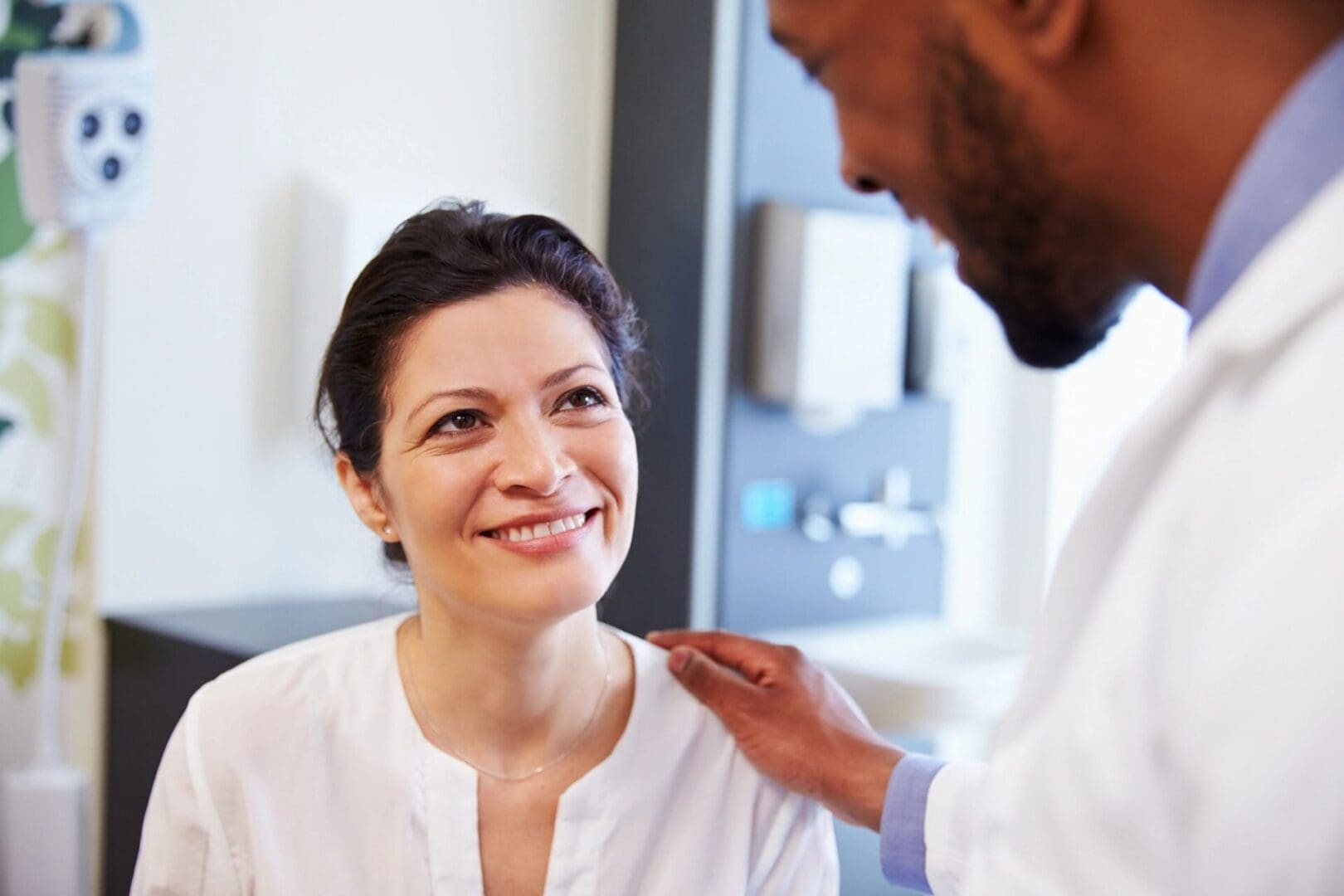 A doctor is talking to a woman in a doctor's office.